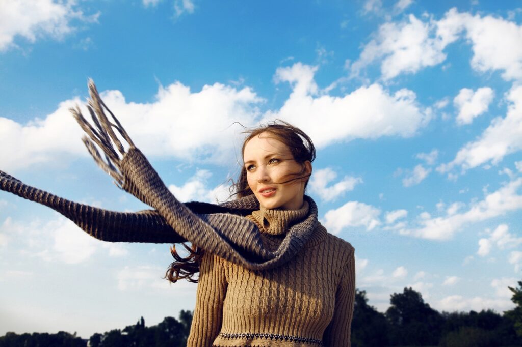 Frau mit Schal vor blauem Himmel