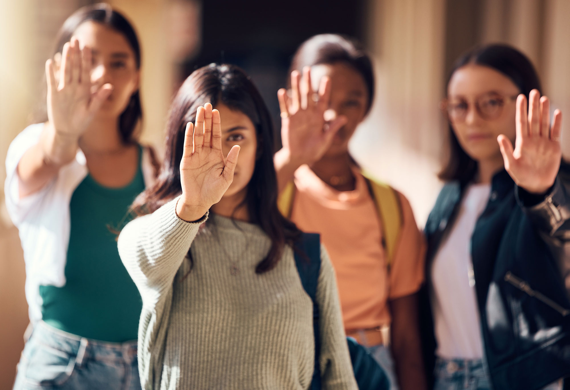 Catcalls: Frauen stehen in einer Reihe mit Stopp zeigender Hand vor dem Gesicht.