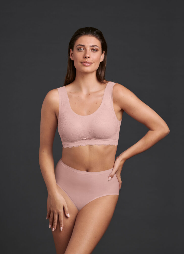 dunkelhaarige Frau trägt rosa Unterwäsche der Essential Serie von Anita.