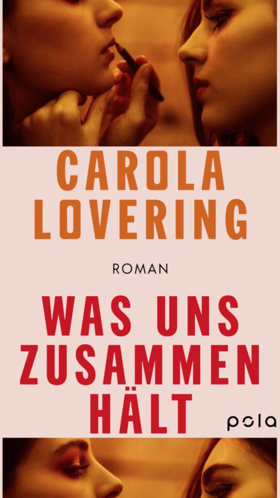 Buch Cover: Im oberen und unteren Teil sind zwei Frauen zu sehen. Die ein schminkt gerden die Lippen der anderen. Dazwischen steht auf rosa Hintergrund: Carola Lovering. Roman. Was uns zusammenhält