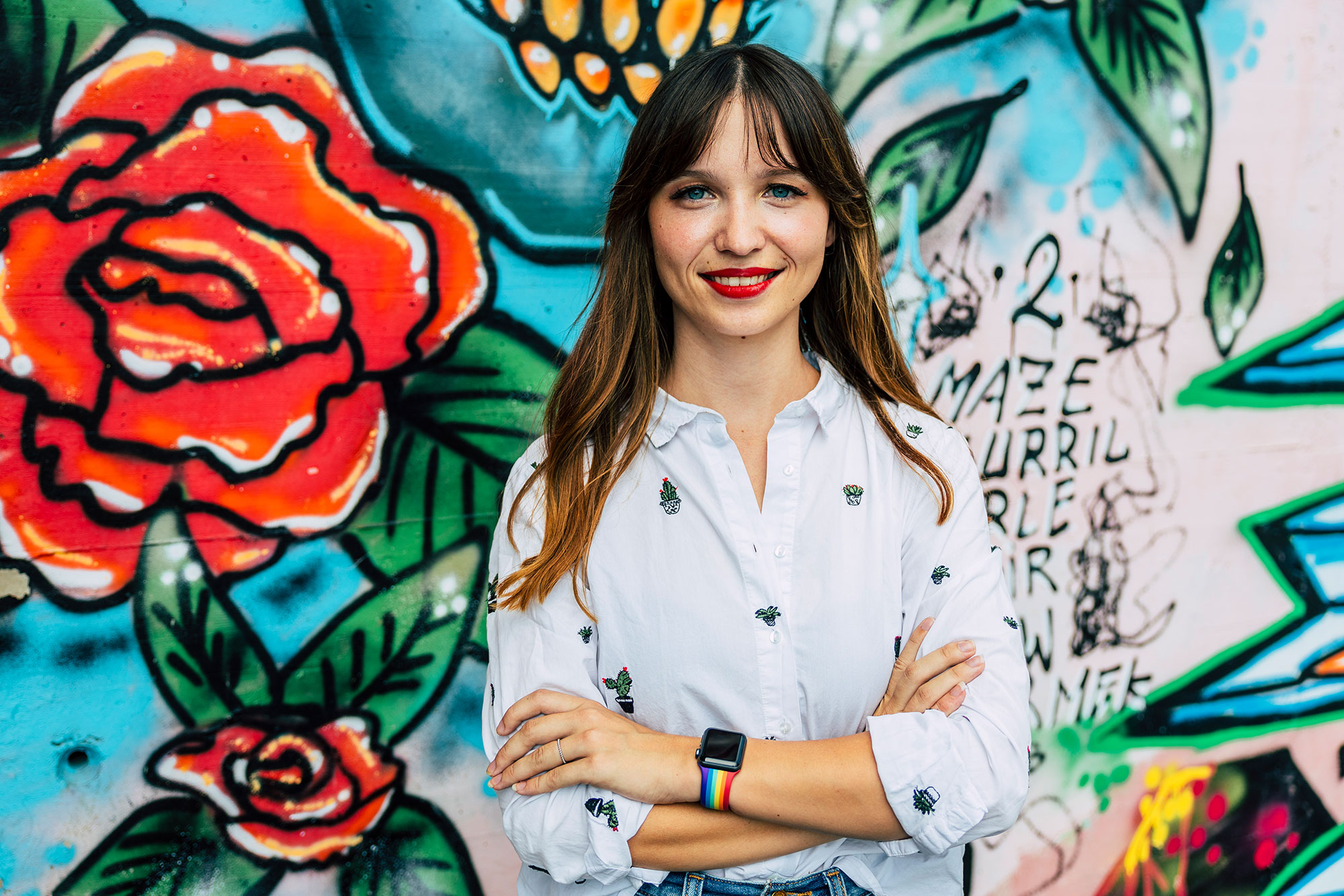 Portrait von Anna Robosch vor einer Graffiti-Wand.