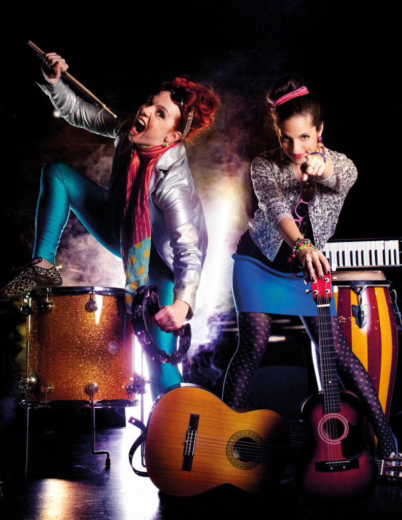 Caroline Athanasiadis und Gudrun Nikodem-Eichenhardt rocken die Bühne in bunten Outfits.