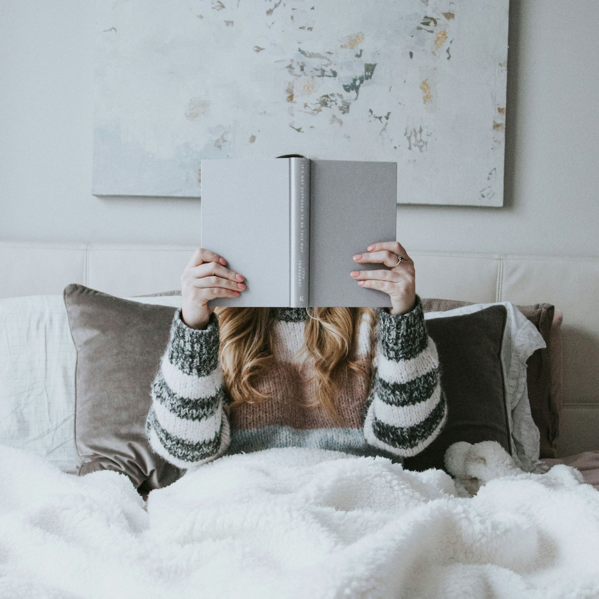 Mutmach-Bücher: Frau liegt im Bett und liest ein Buch.