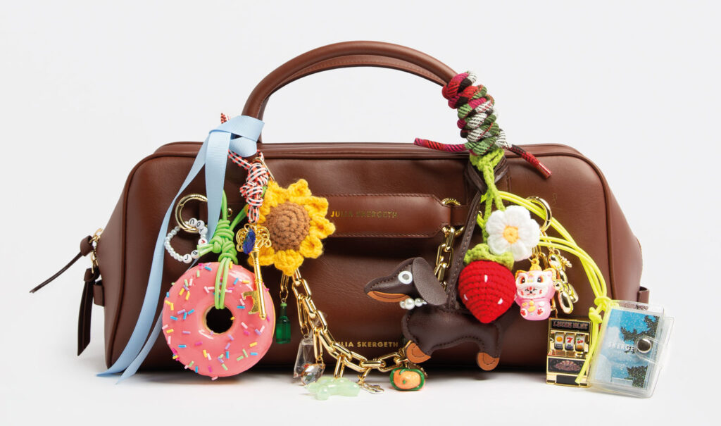 Braune Ledertasche mit ganz vielen bunten Anhängern.