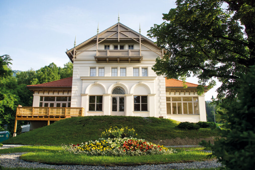Schönes Haus mit Blumenschmuck-Garten davor.