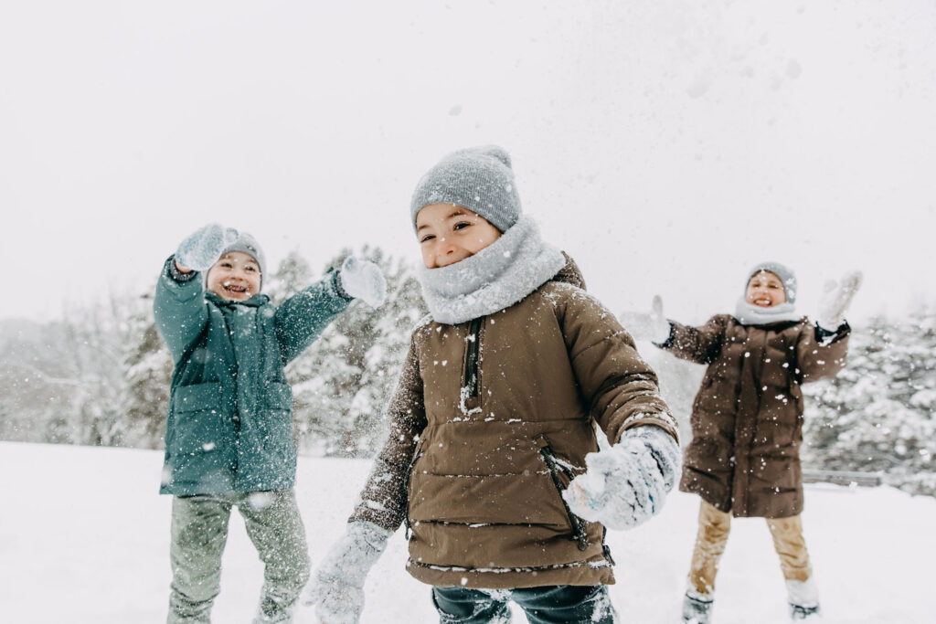Kindergesundheit: Drei Kinder spielen im Schnee