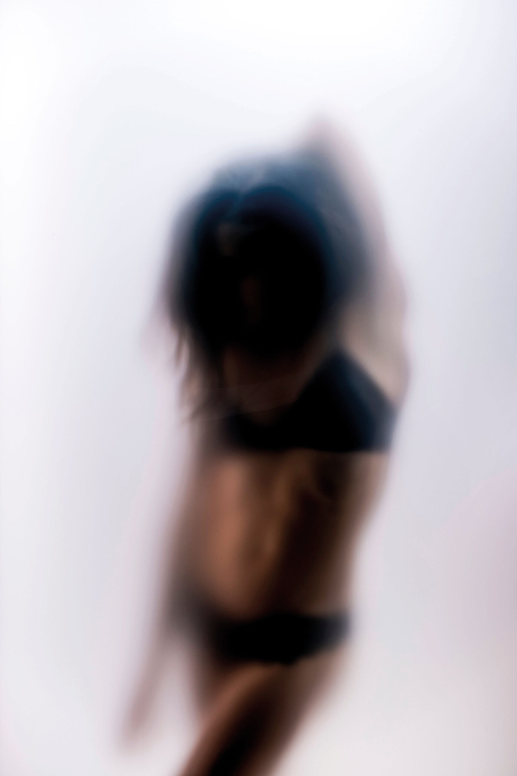 Verschwommenes Bild einer Frau in schwarzer Unterwäsche.