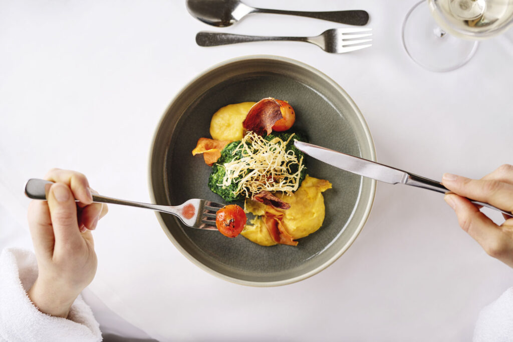 Ein Teller von oben mit leckerem Essen aus der Ego-Perspektive einer Frau beim Essen.