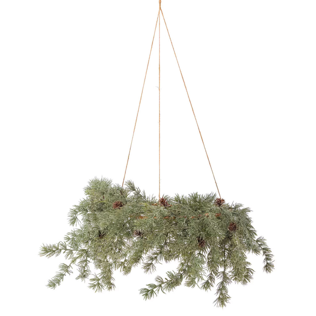 Hängender Kranz aus Tannenzweigen mit ein paar Zapfen dazwischen.