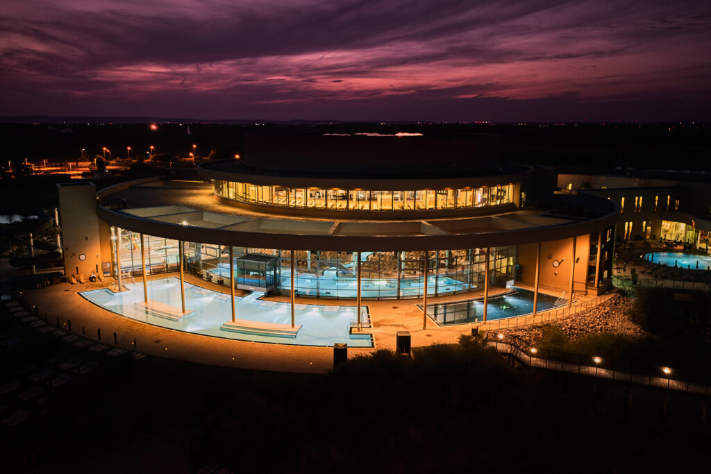 Bewegung im Winter: Aussenaufnahme einer Therme bei Nacht