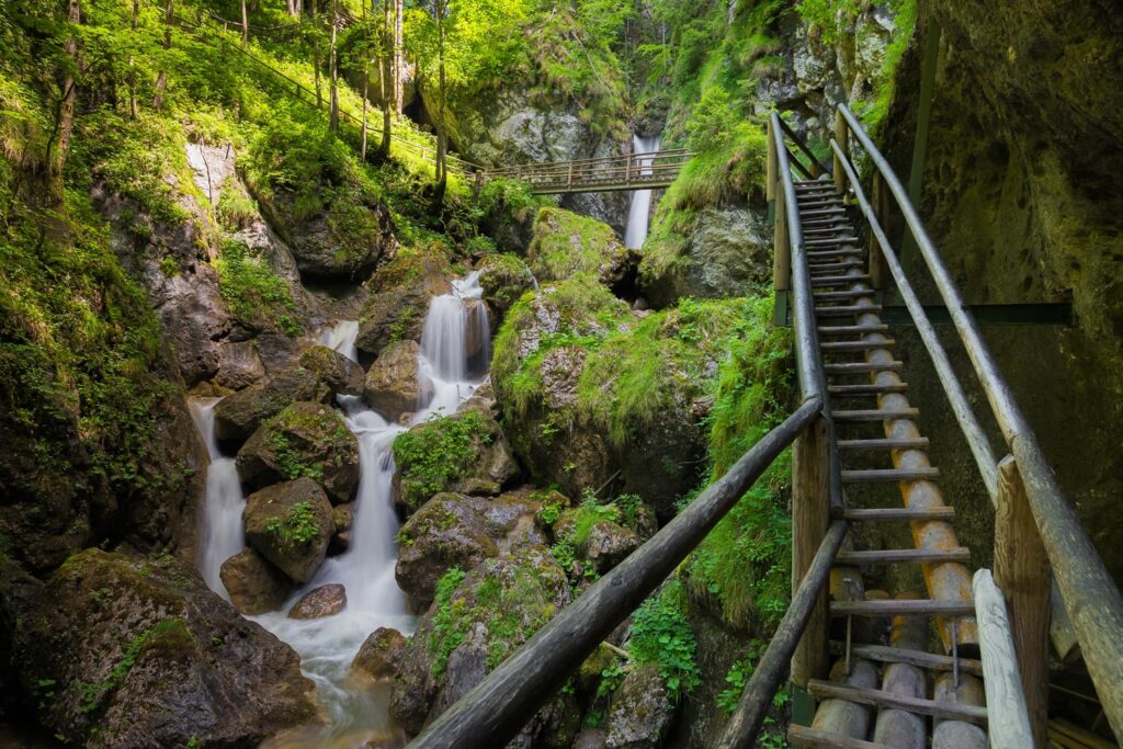 Bärenschützklamm: Ein hölzerner Aufstieg führt über begrünte Wasserfälle.