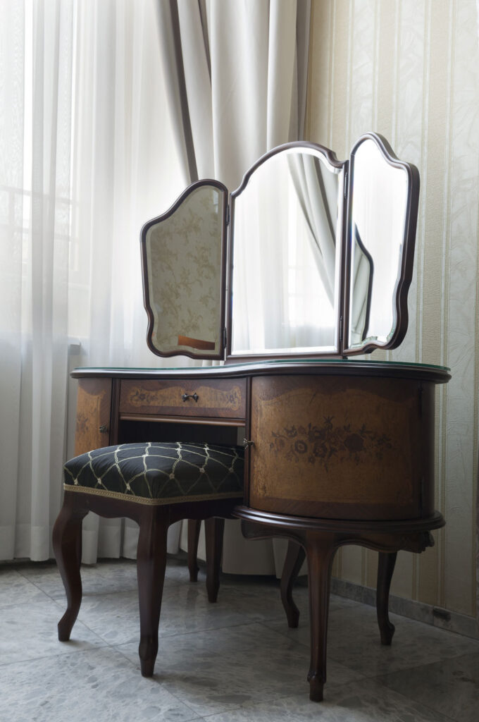 Sustainable Luxury: Antiker Schminktisch mit Stuhl in hellem Raum.