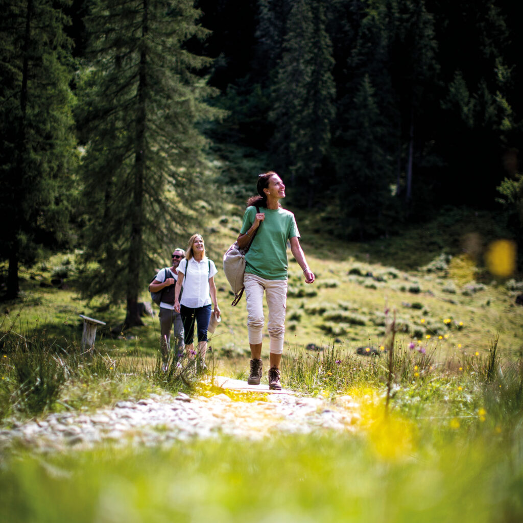 Zwei Frauen und ein Mann beim Wandern.