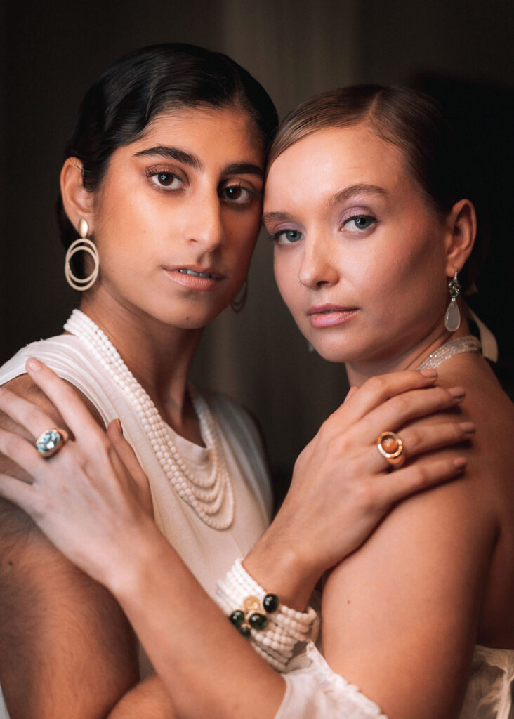 Zwei elegante Frauen tragen viel Schmuck.