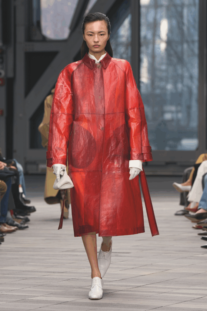 Model für Calvin Klein in rotem Mantel und mit Sleek Hair-Look auf der Fashion Week 2026