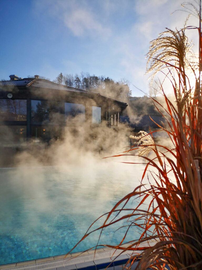 Becken mit dampfendem Thermalwasser im Freien.