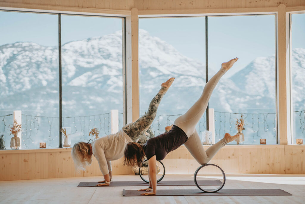 Yogawheel mit zwei Frauen und Winter-Landschaft im Hintergrund