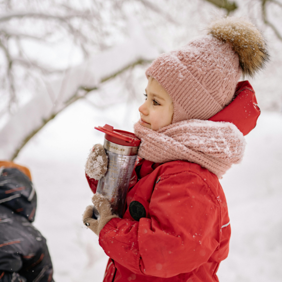 Hysan Salinspray: Ein Kind im Schnee mit Haube, Schal und Skianzug, hÃ¤lt eine Teekanne