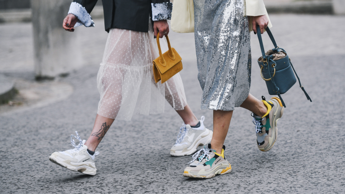 Tirolerin Outfit-Ideen, Thema RÃ¶cke, zwei Frauen gehen in stylischen Outfits der StraÃe entlang, detaillierte Aufnahme, Sneaker, Sporty Spice